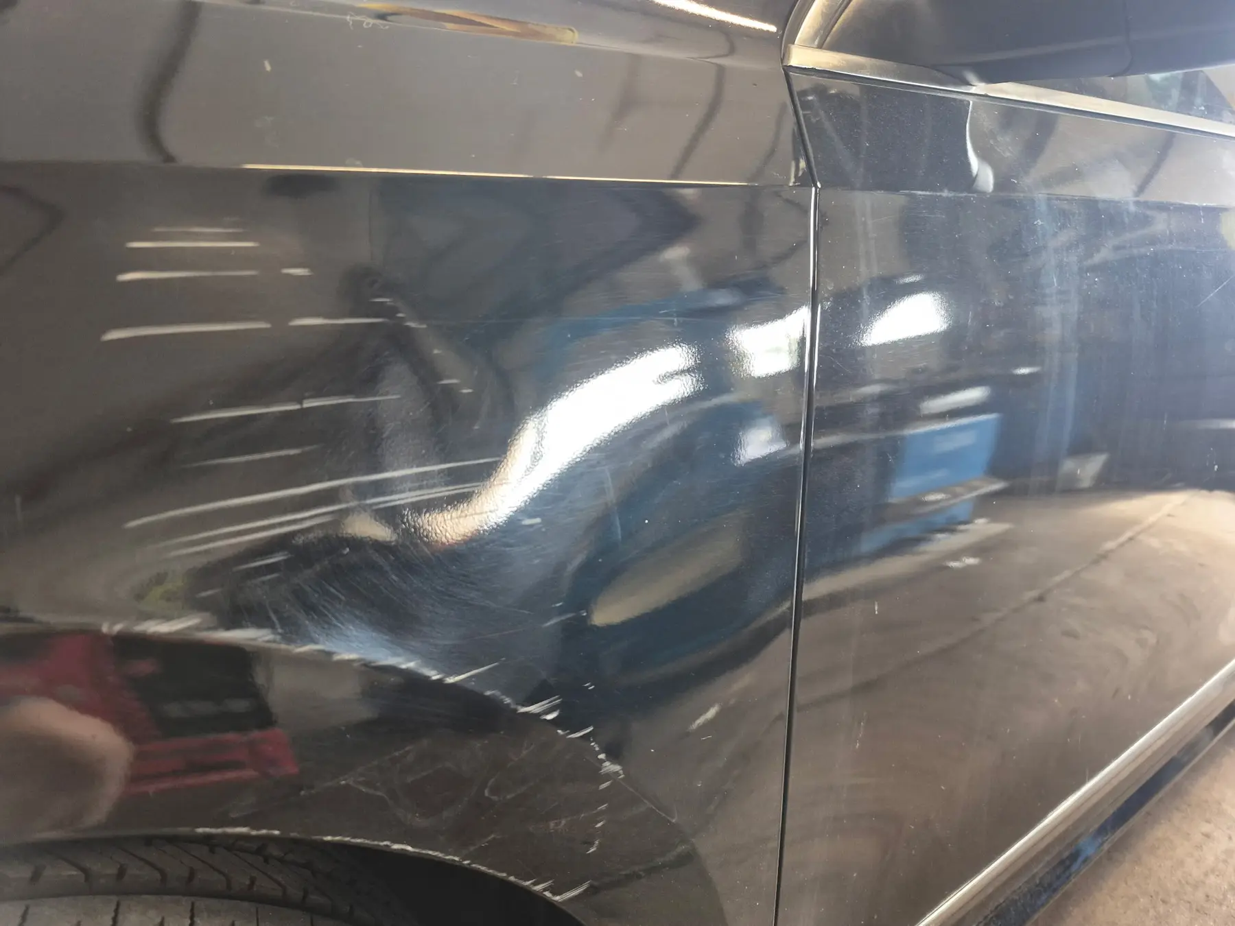 Scratches on black car door before polishing